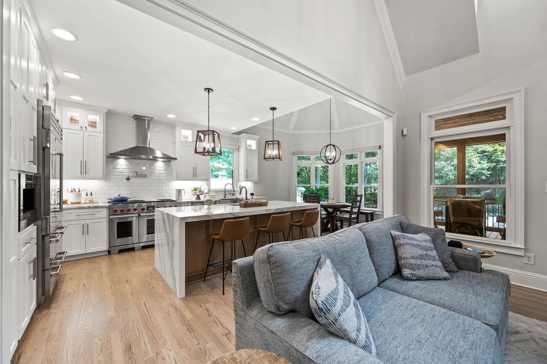 Spacious, modern kitchen with a large island, stainless steel appliances, and a gray couch.