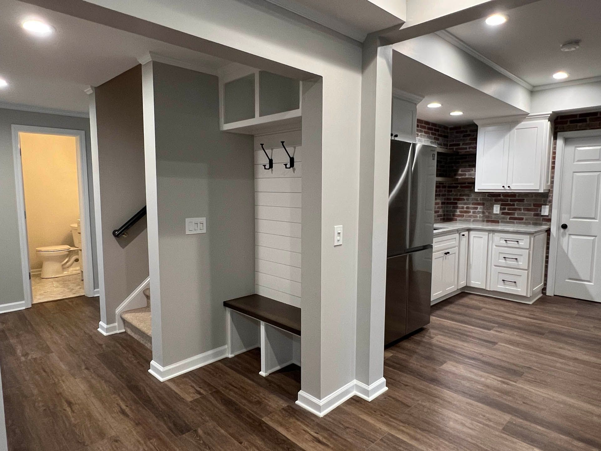 a kitchen with white cabinets and a stainless steel refrigerator