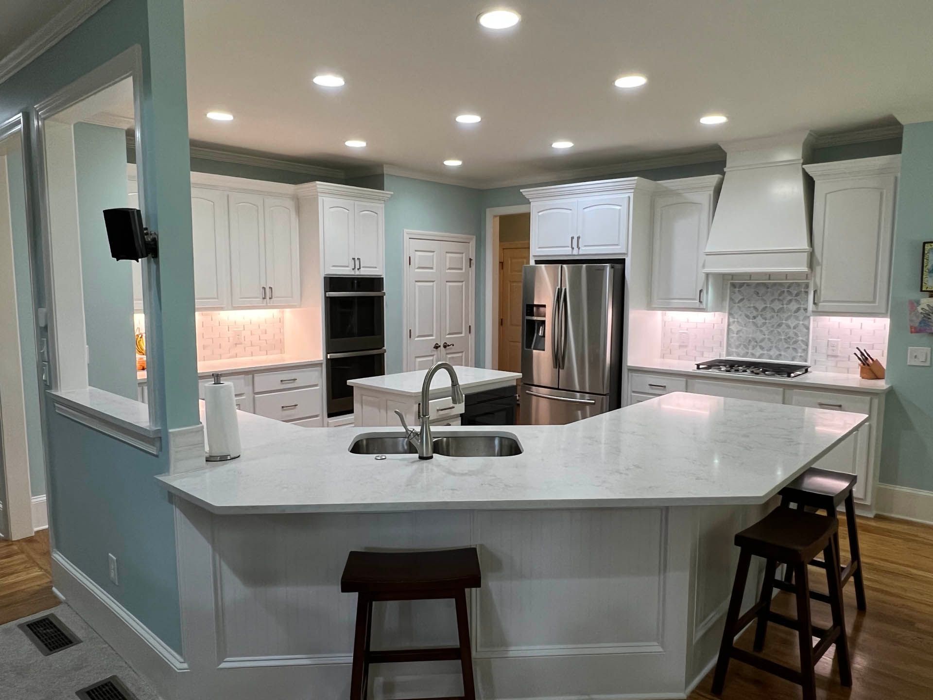 a kitchen with white cabinets and a stainless steel refrigerator