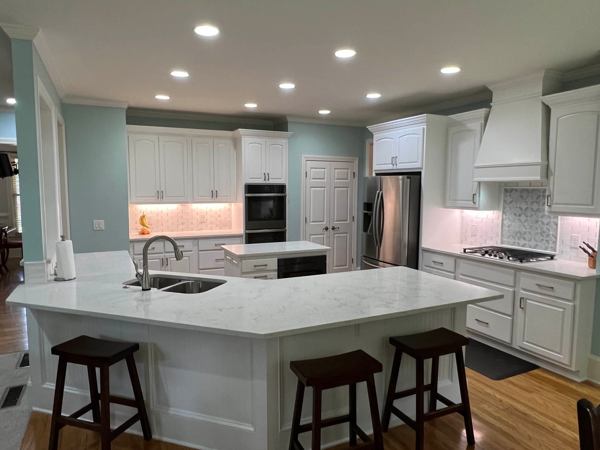 a kitchen with white cabinets and a stainless steel refrigerator