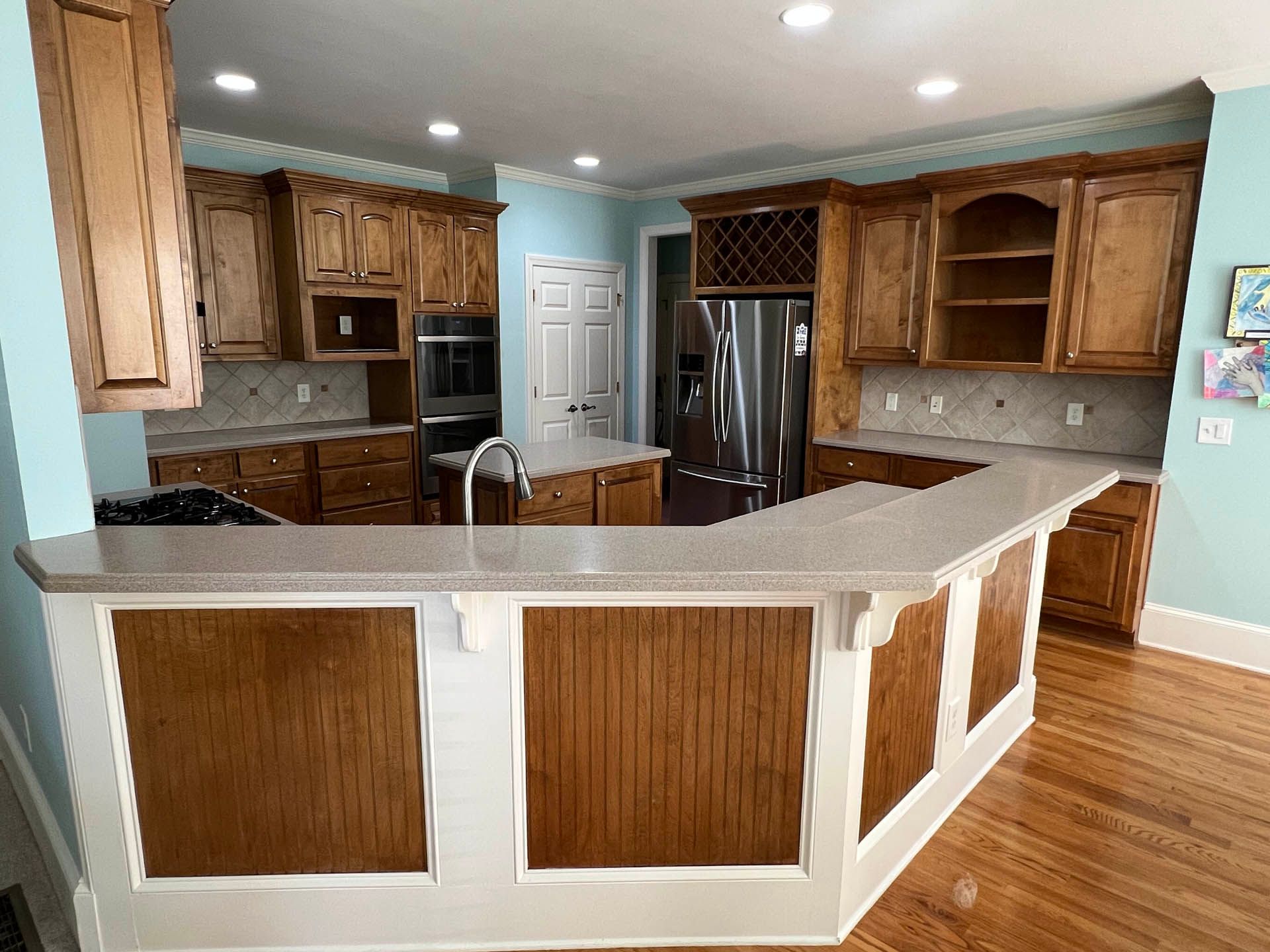 a kitchen with wooden cabinets and a stainless steel refrigerator