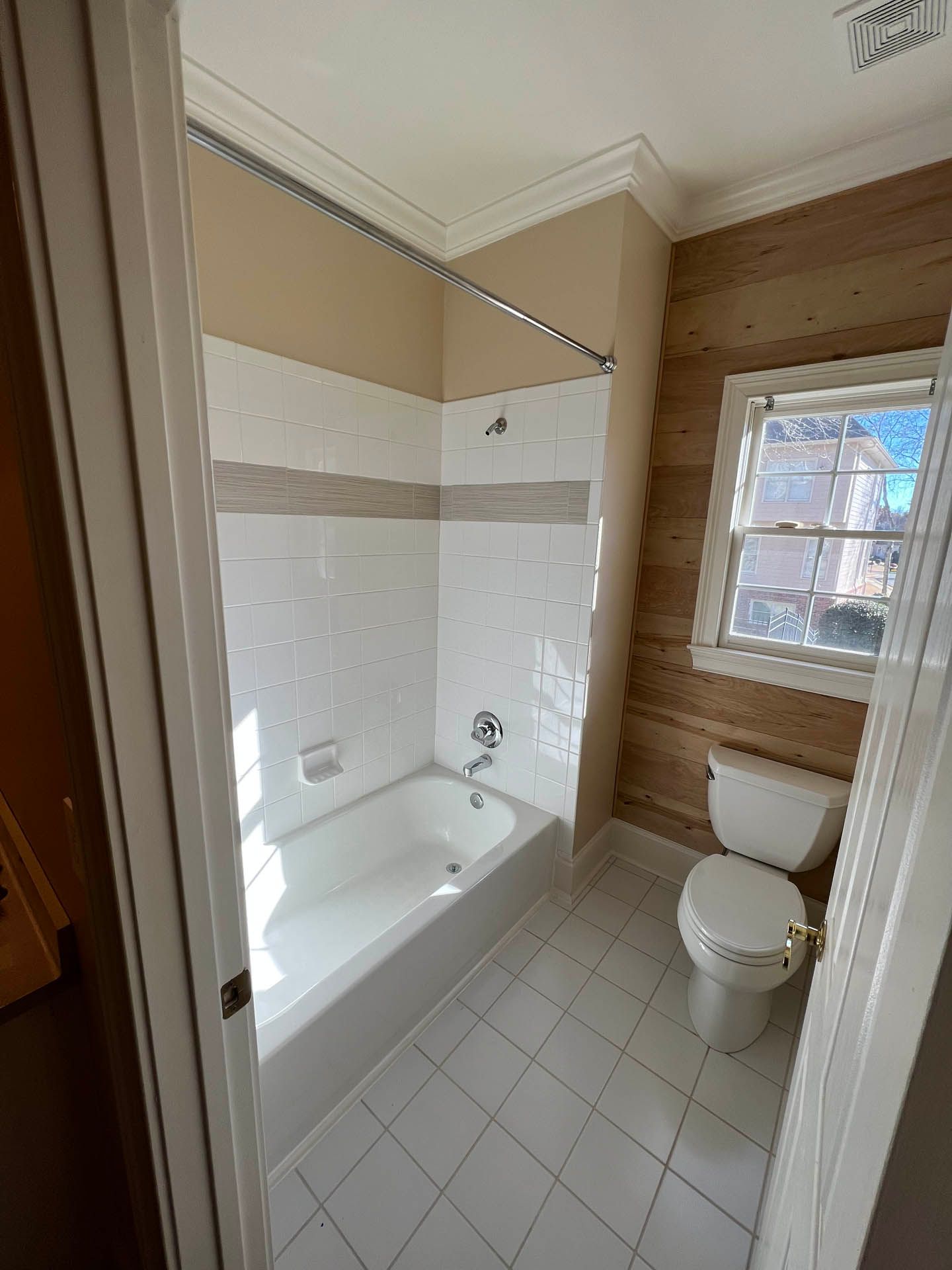 a bathroom with a tub and toilet and a window
