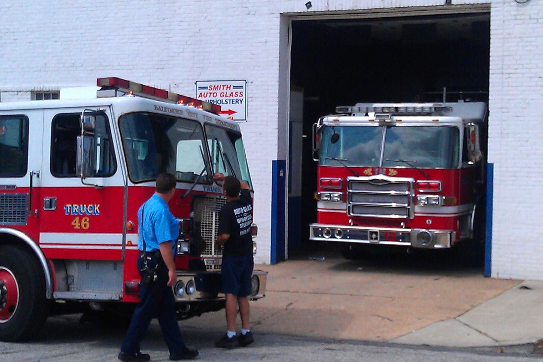 baltimore city fire trucks parked inside of smith auto glass for a new windshield