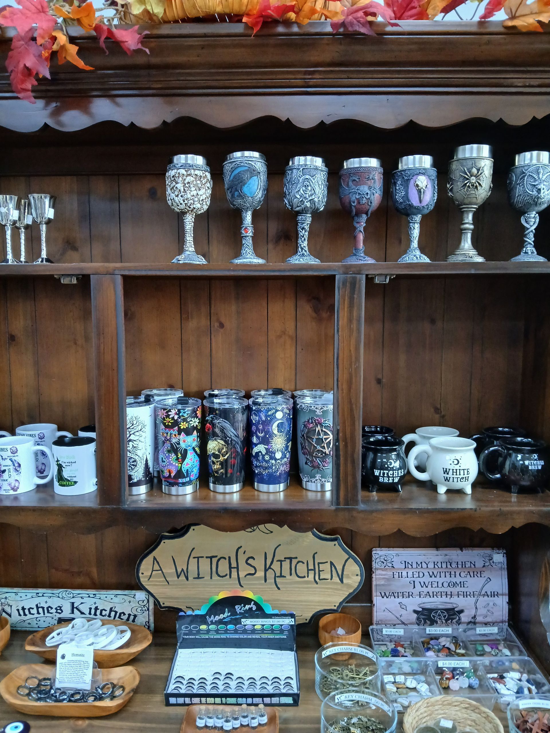 Wooden shelves filled with decorated glasses, mugs, and a sign that reads 
