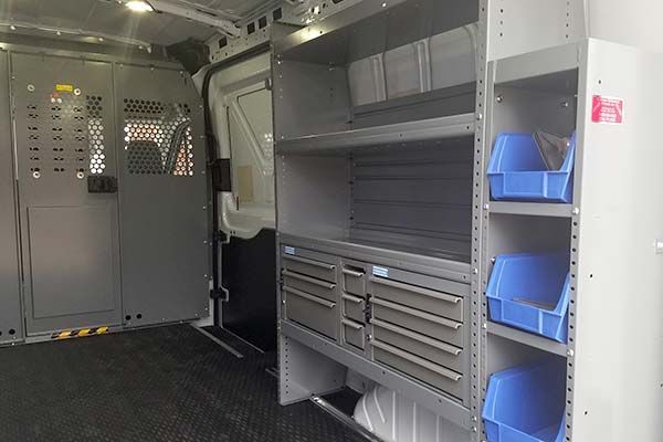 The inside of a van with shelves and bins.