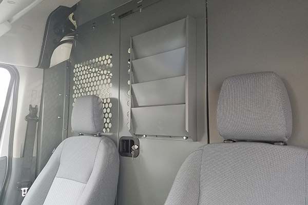 The inside of a van with a shelf between the seats.