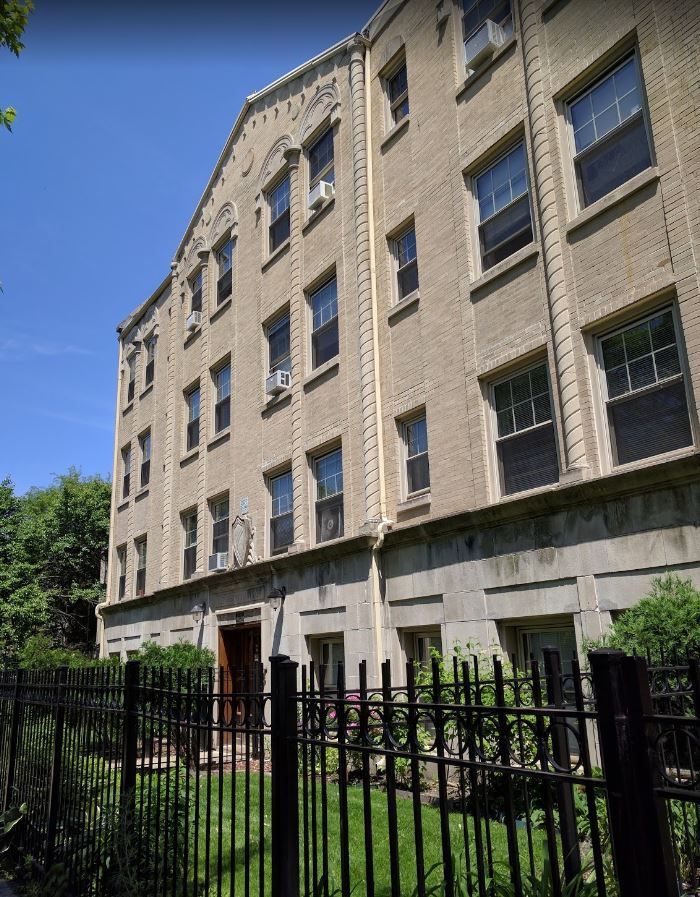 A large brick building with a fence in front of it