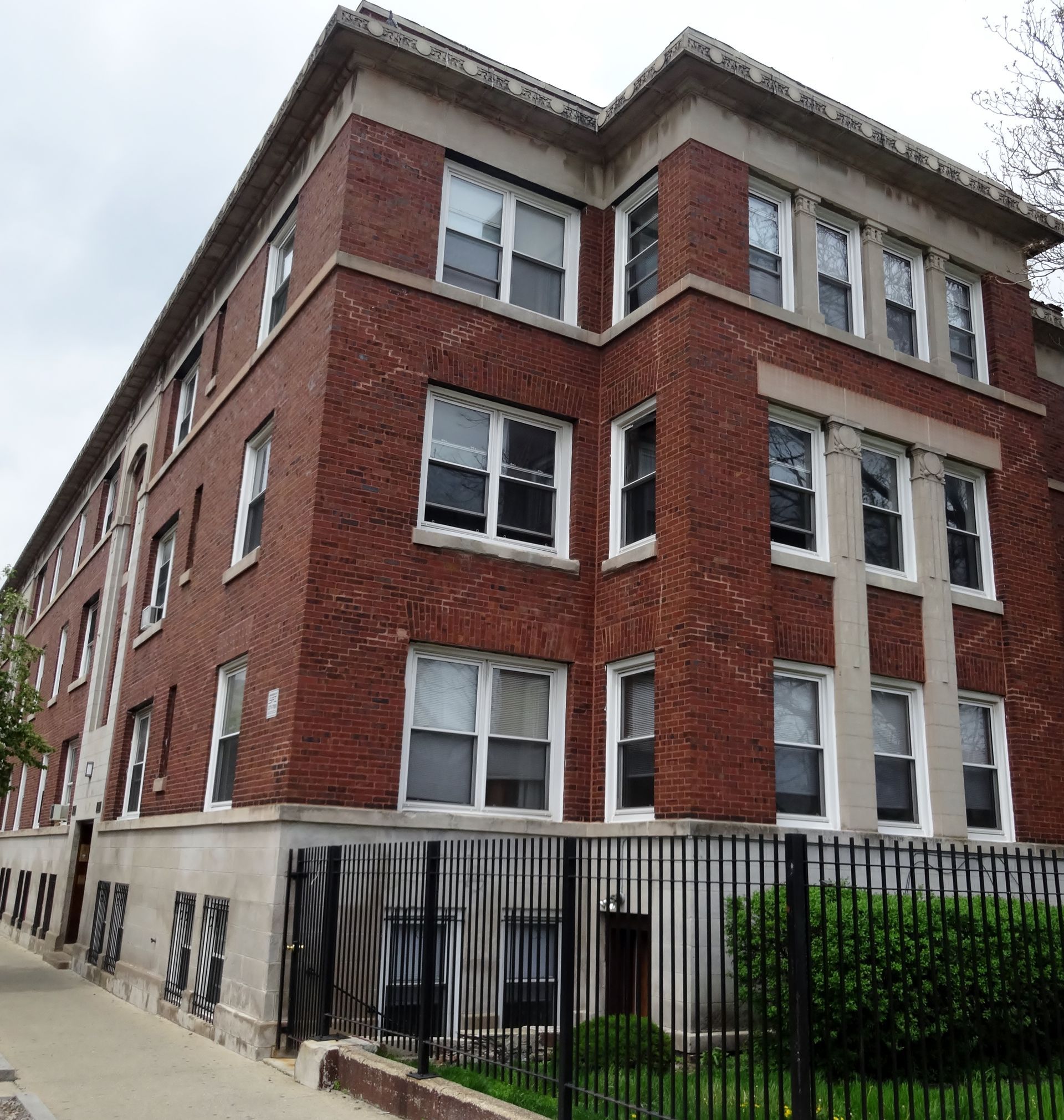 A large brick building with a fence around it