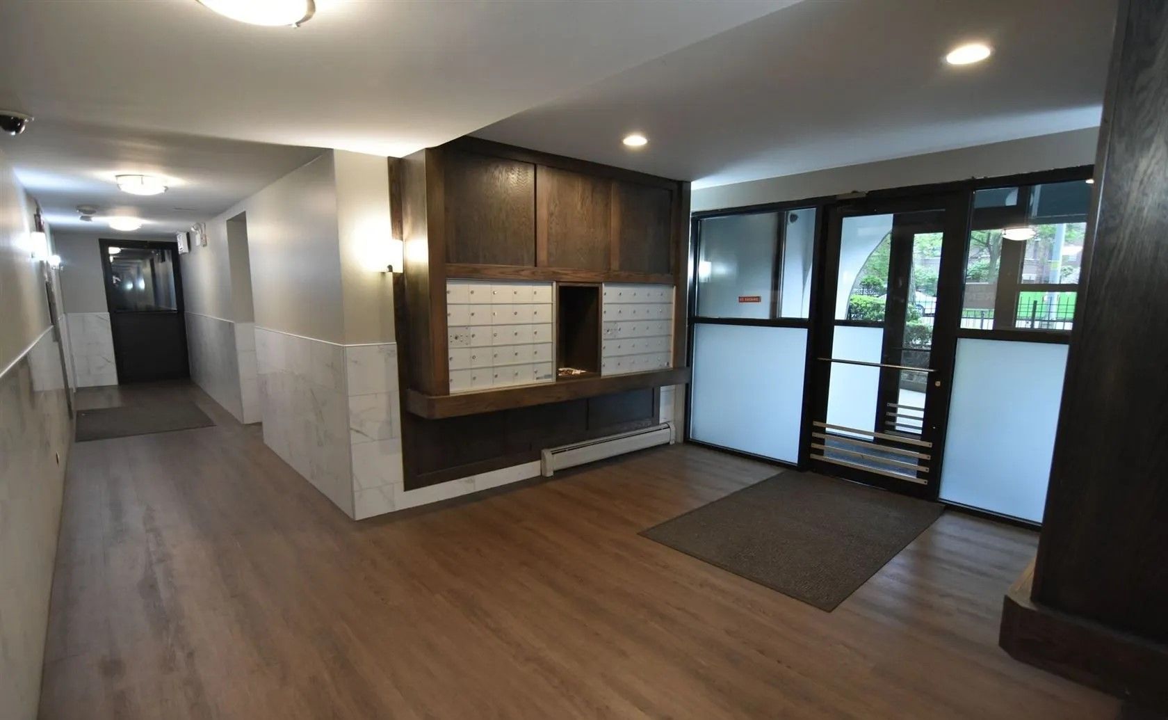 A hallway with wooden floors and a sliding glass door