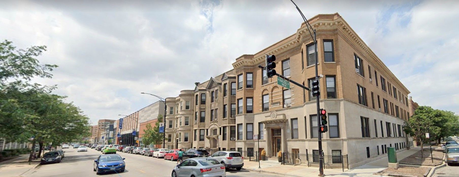 A large building is on the corner of a city street.