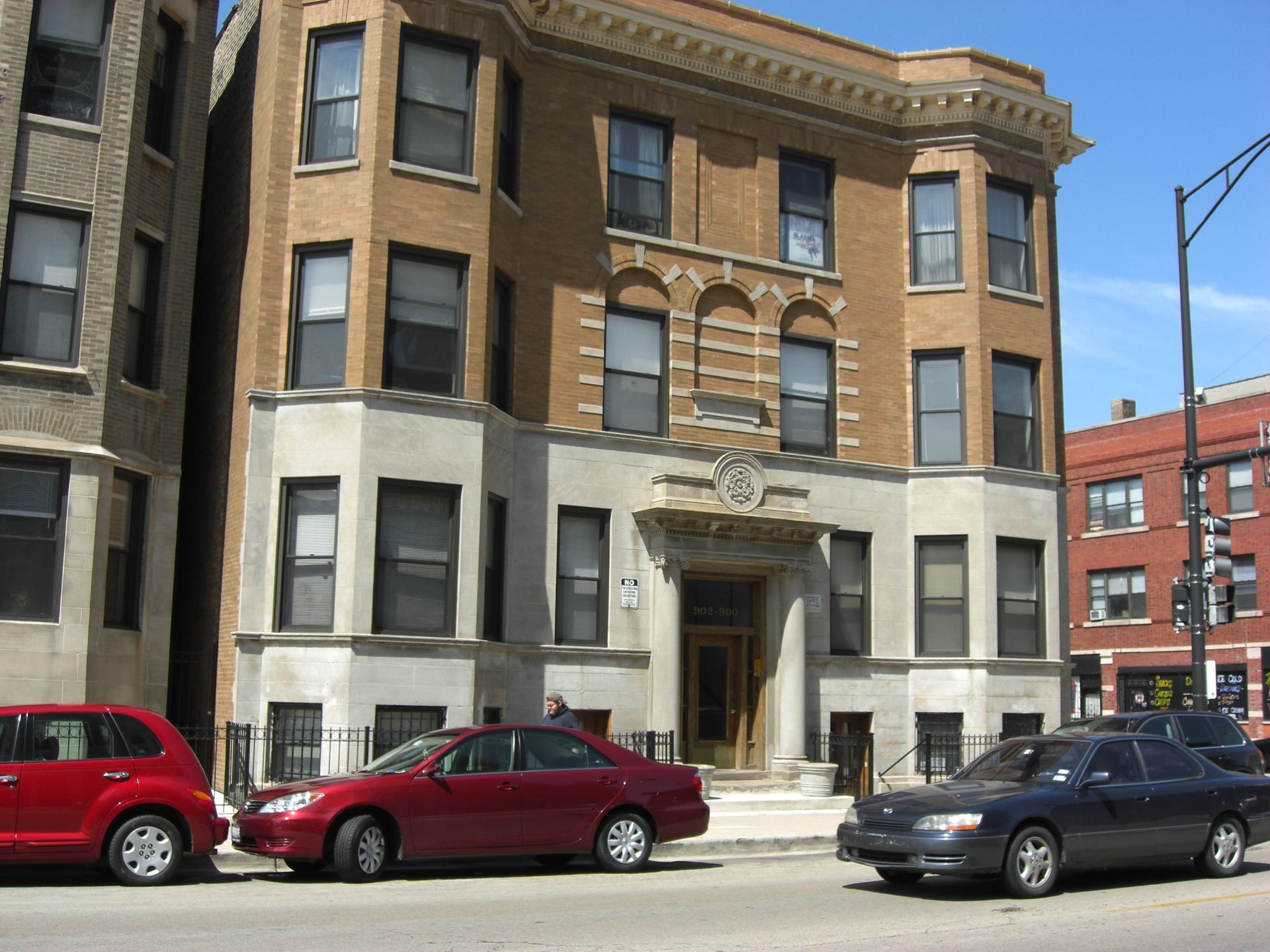 A red car is parked in front of a building