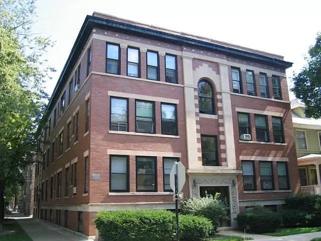 A large brick building with a stop sign in front of it