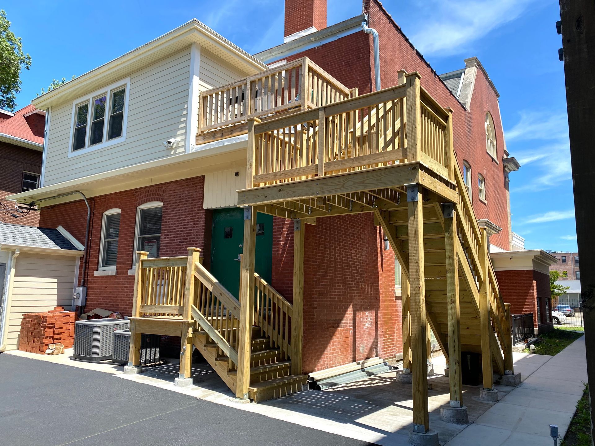 A brick house with a wooden deck and stairs