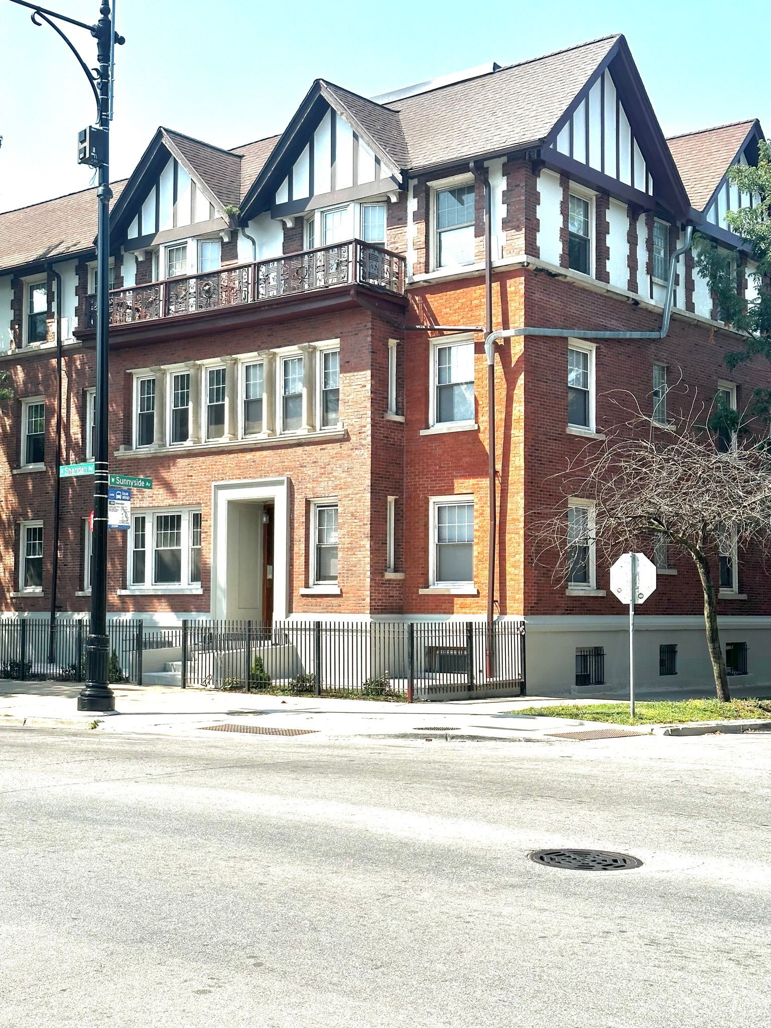 A large brick building is on the corner of a street.