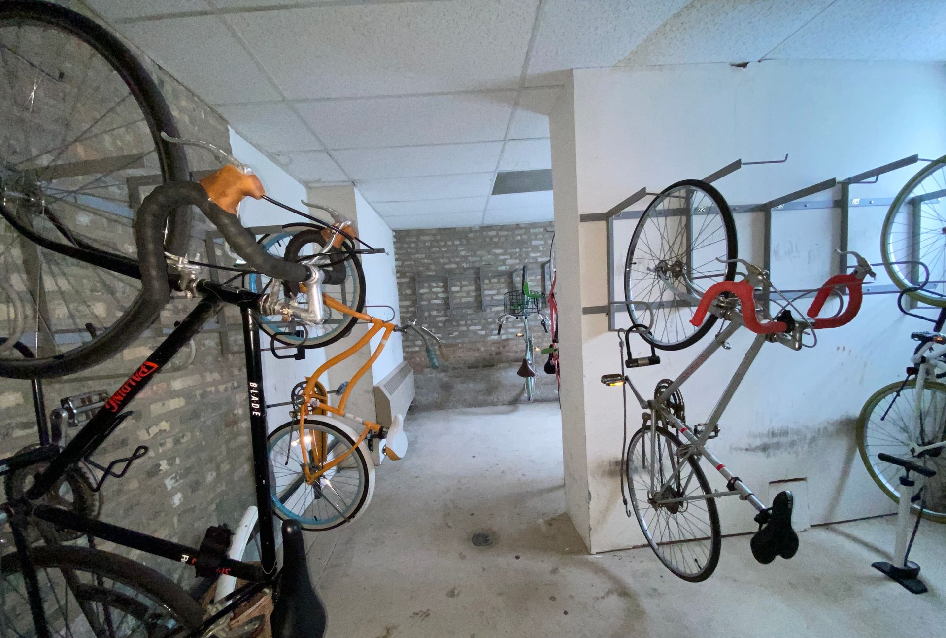 A bunch of bikes are hanging on a wall in a room