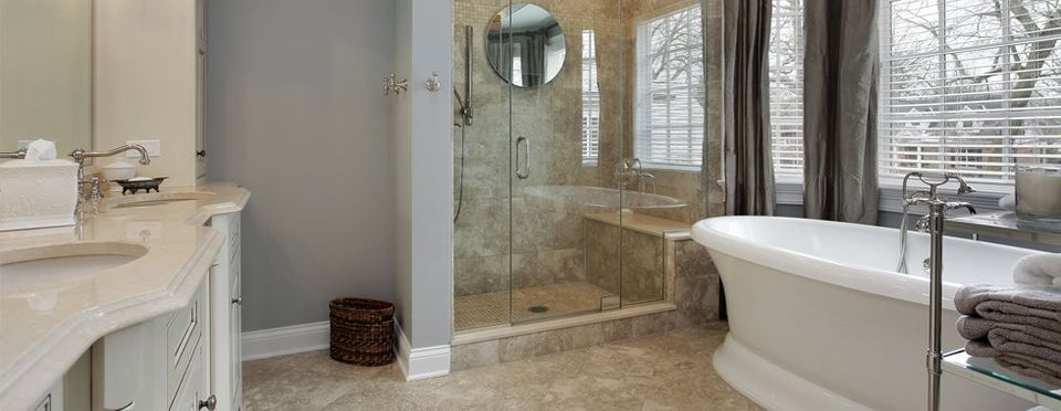 A stylish bathroom with a rolltop bath and glass shower