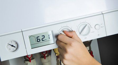 A boiler thermostat being turned