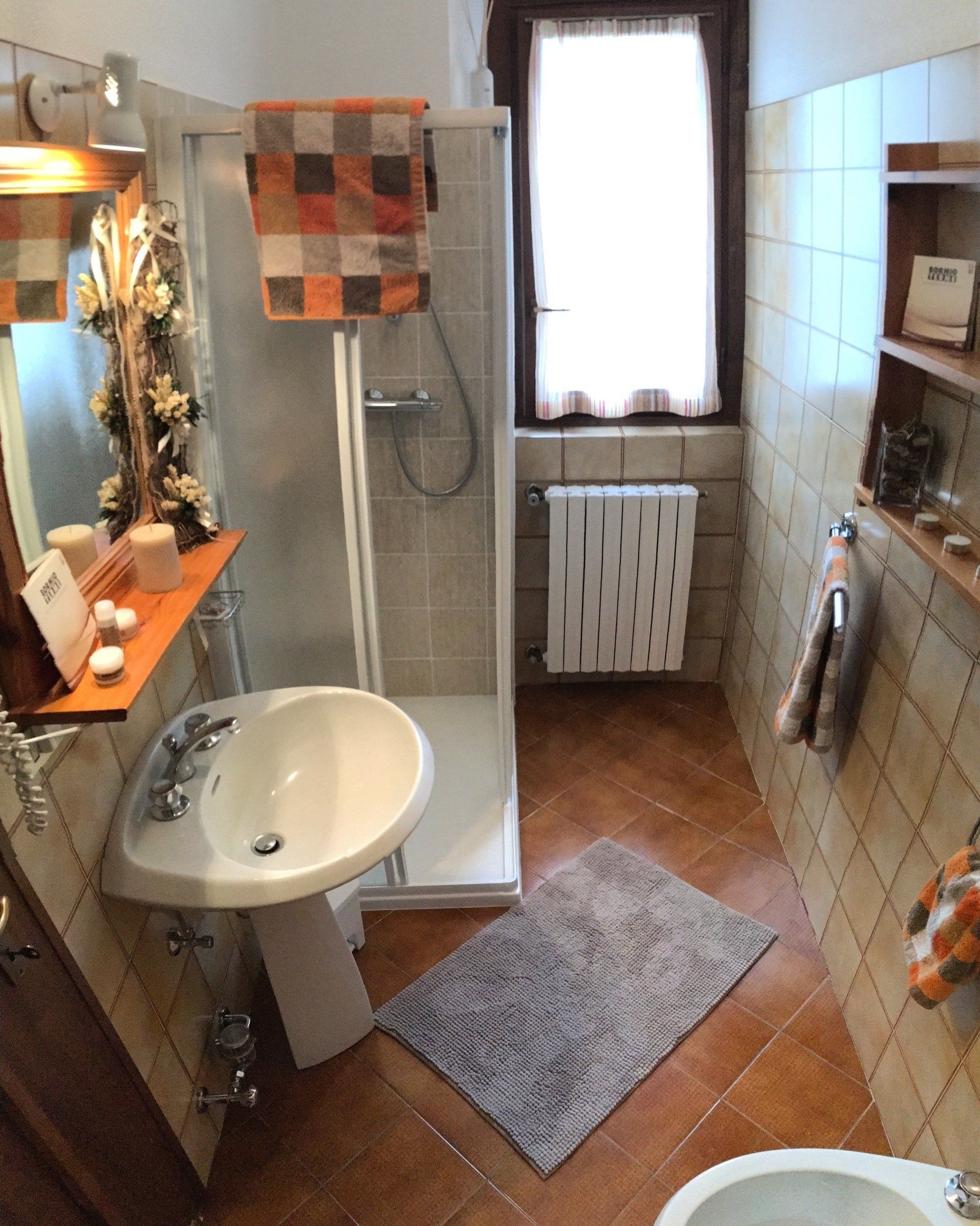 Un bagno con lavandino, wc e doccia