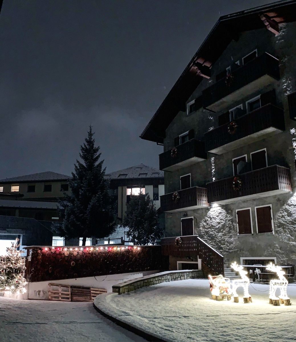 Un grande edificio con la neve a terra davanti ad esso