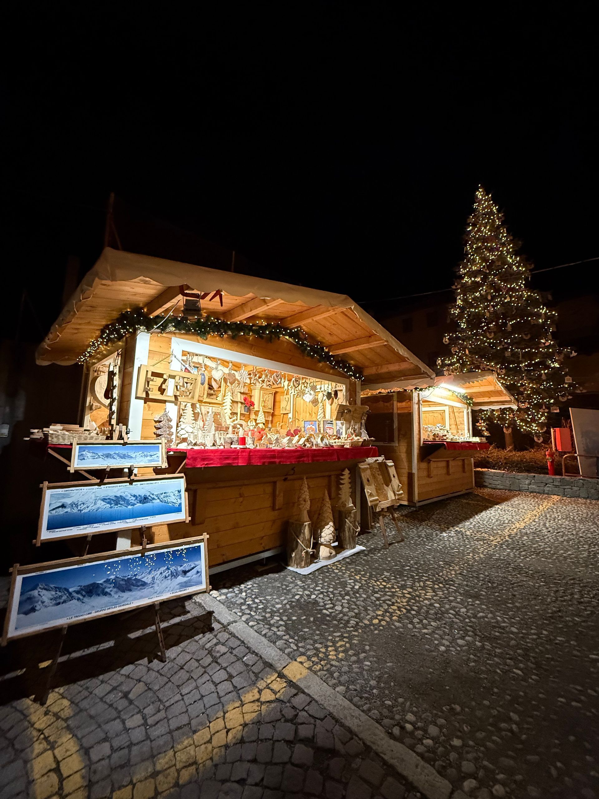 A christmas market with a christmas tree in the background