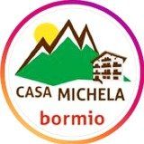 Il logo di casa michela bormio ha sopra una montagna e una casa.