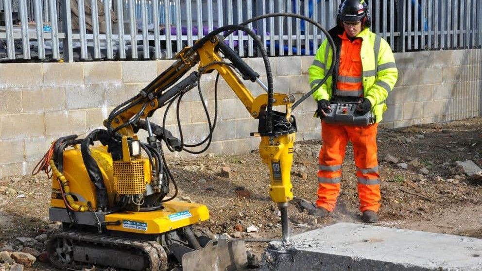 A man is standing next to a small yellow machine.