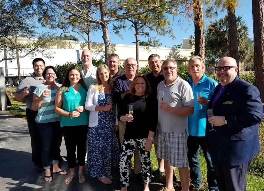 Men and Women Holding Champagne Glasses — Naples, FL — Home Watch Academy