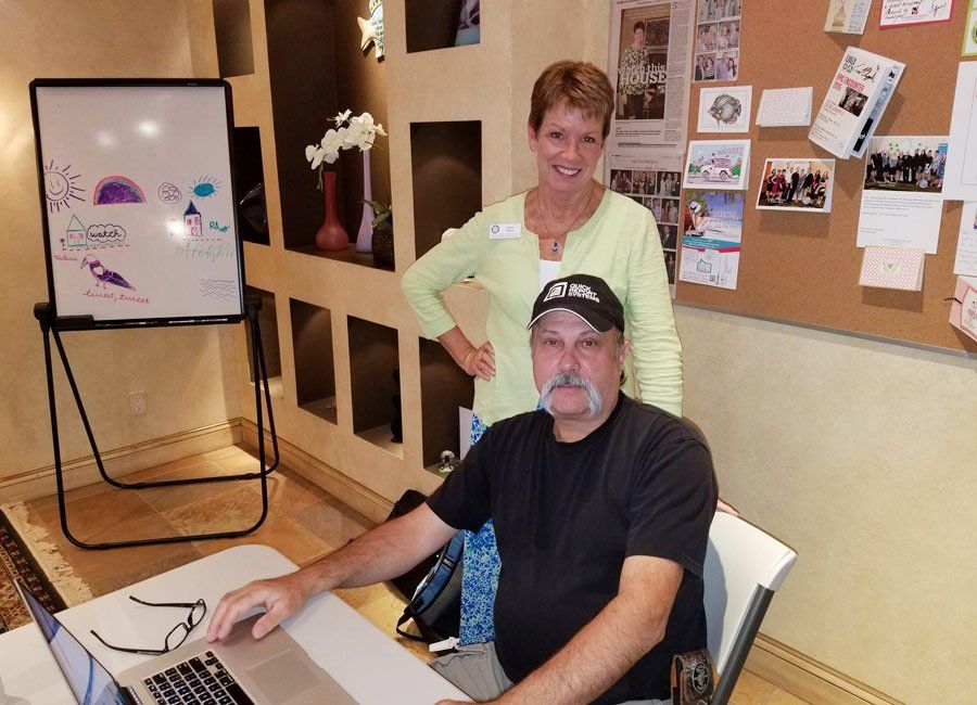 Diane Pisani and a Man Working on His Laptop — Naples, FL — Home Watch Academy
