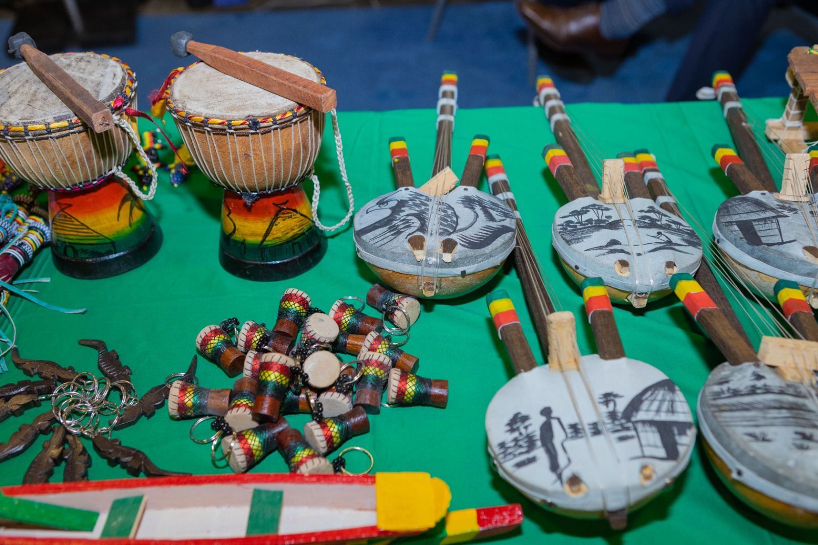 People in colorful patterned outfits playing drums outdoors.