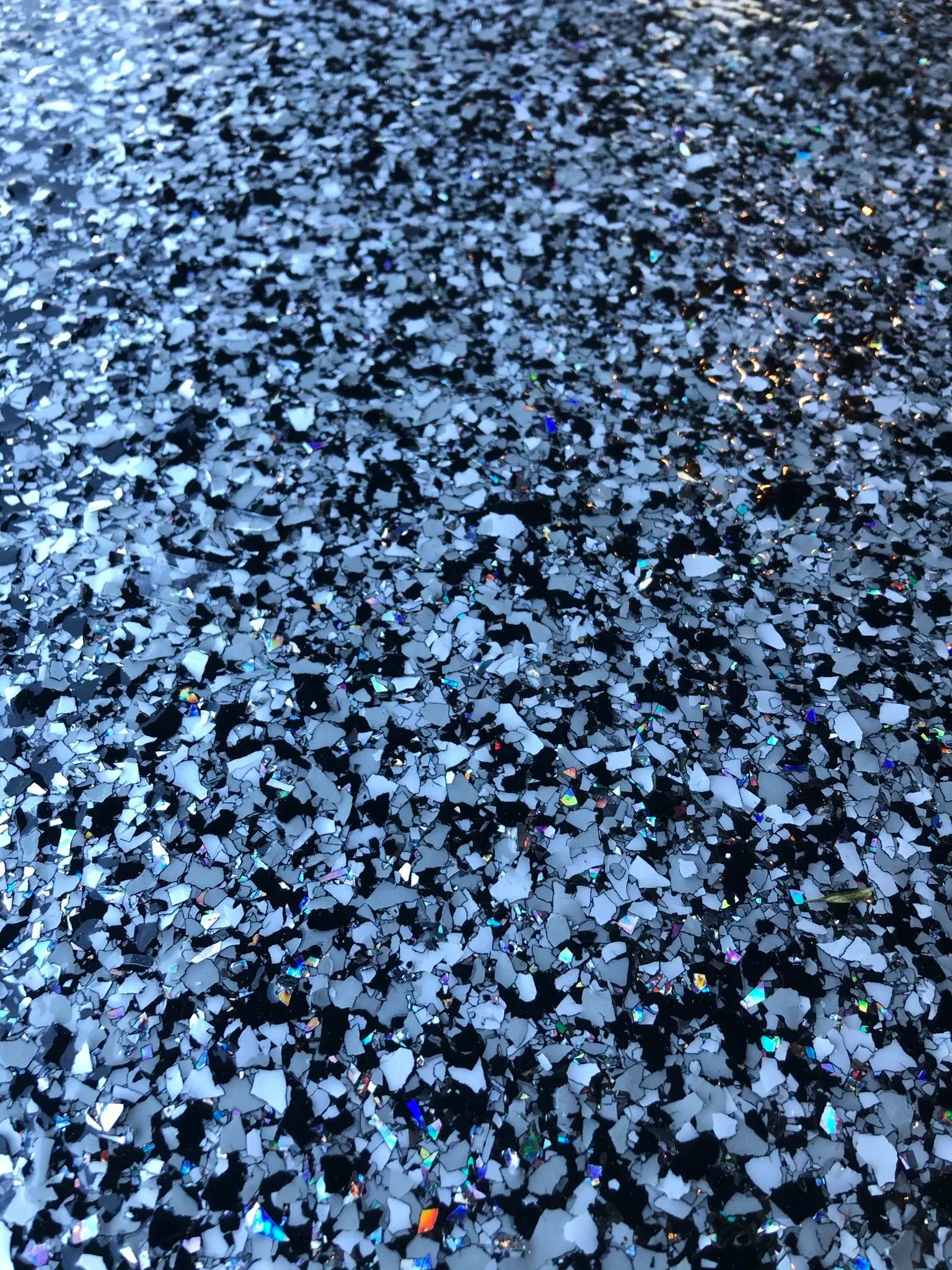 Close-up of a speckled floor with black, white, and iridescent chips.