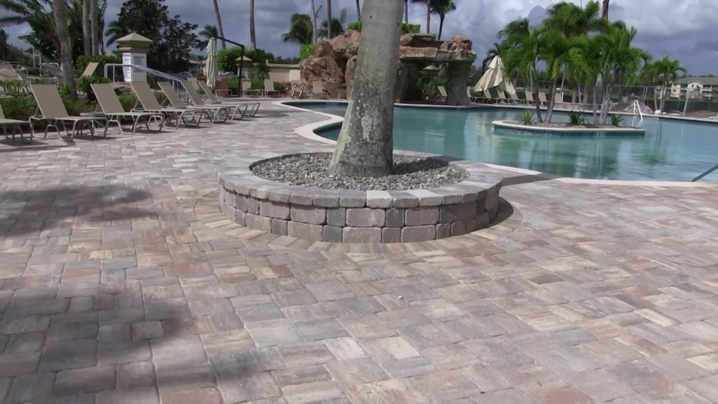 a pond with a waterfall and an umbrella in the backyard
