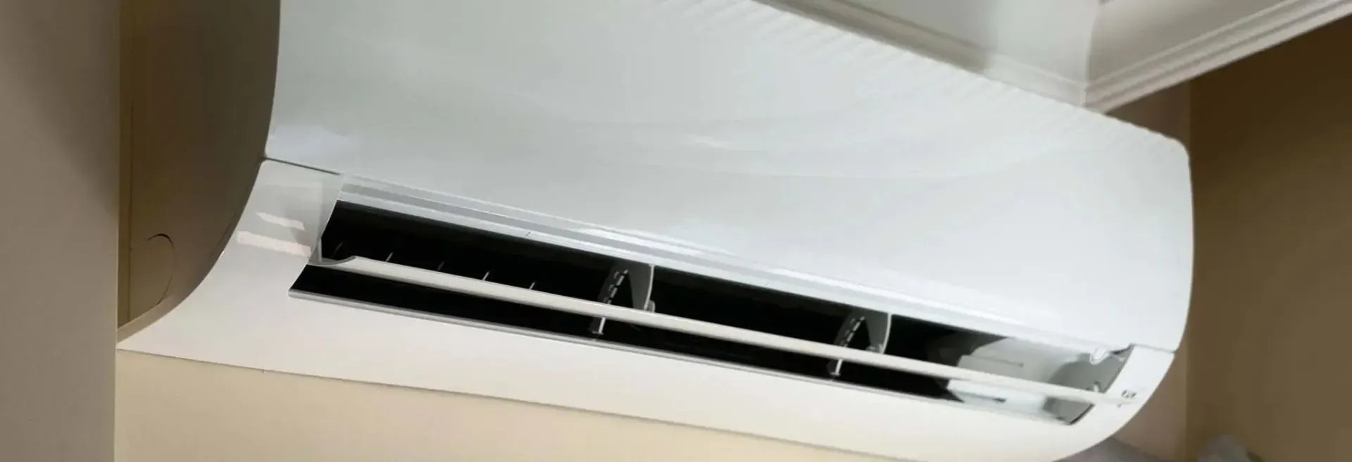 A white air conditioner is hanging on a wall in a room.