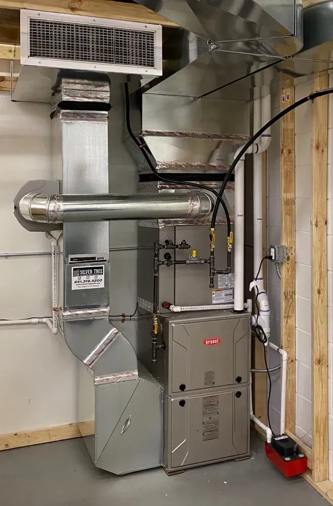 A furnace is sitting in a room next to a wall.