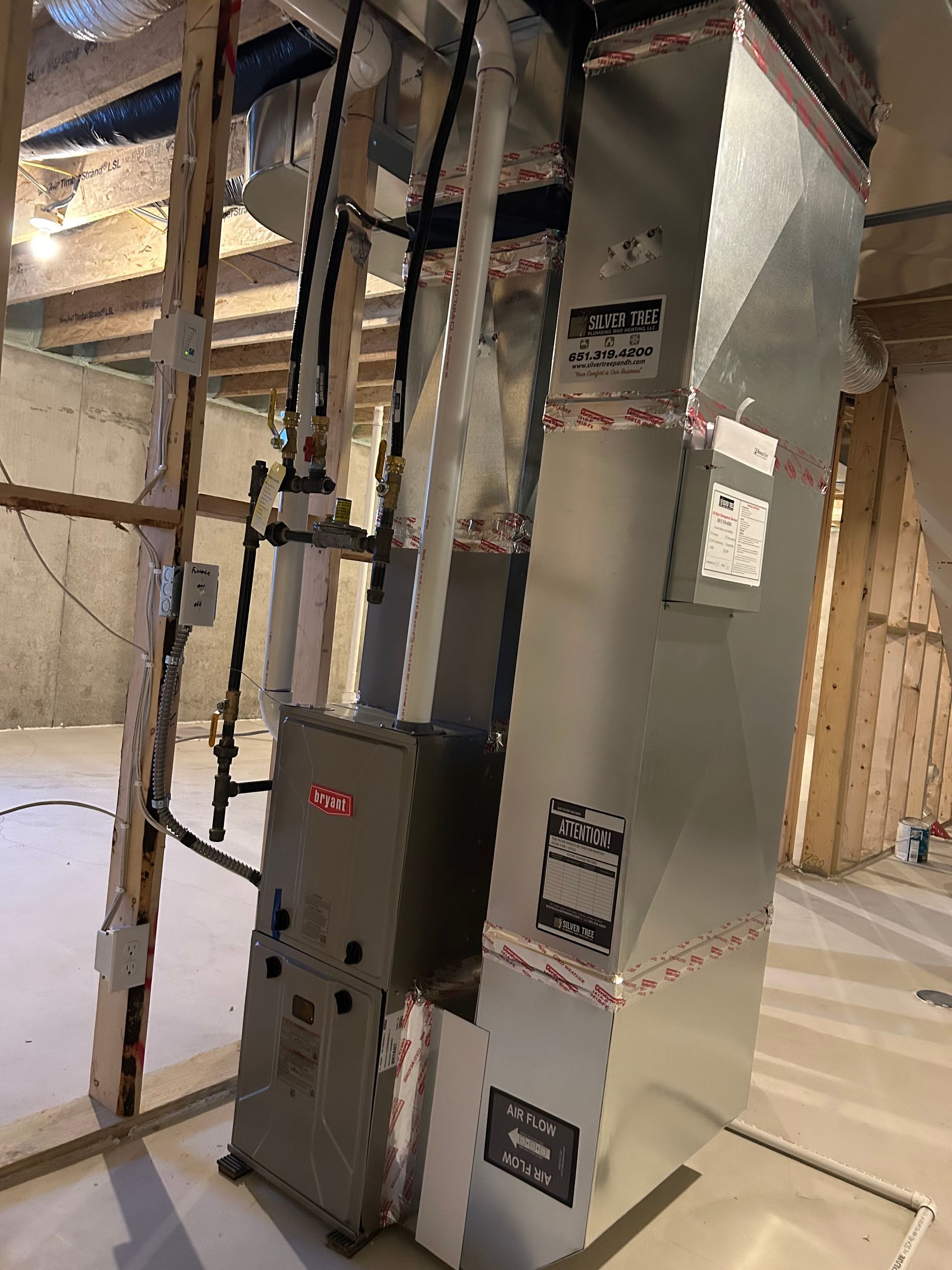 An air conditioner is sitting in a basement under construction.