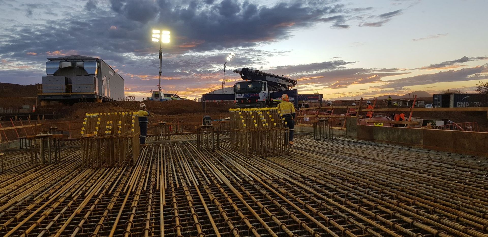 A construction site with a sunset in the background.
