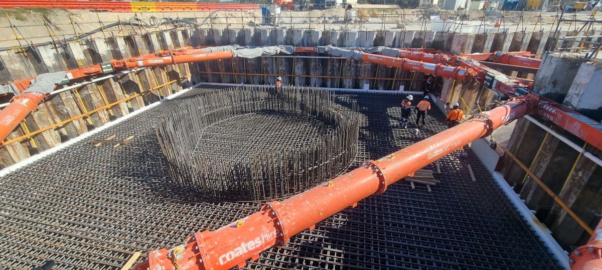 A large pipe is being used to pump concrete into a hole.