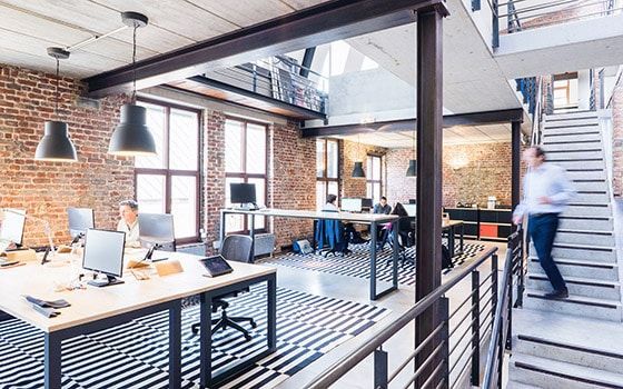 A man is walking down a set of stairs in an office.