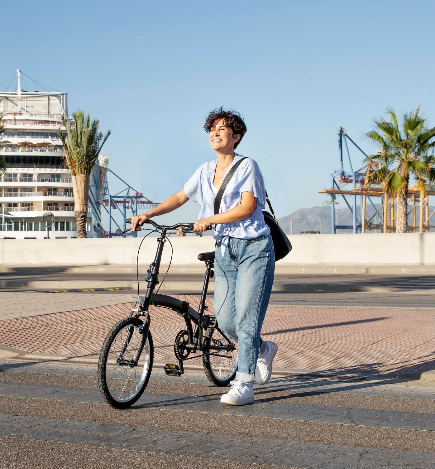 A woman is riding a folding bike down a street.