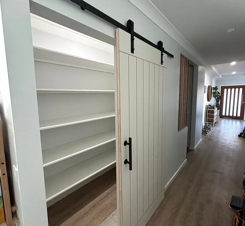 Built-in White Storage Cabinets with a Sliding Barn Door — The Wright Way Building In North Albury, NSW