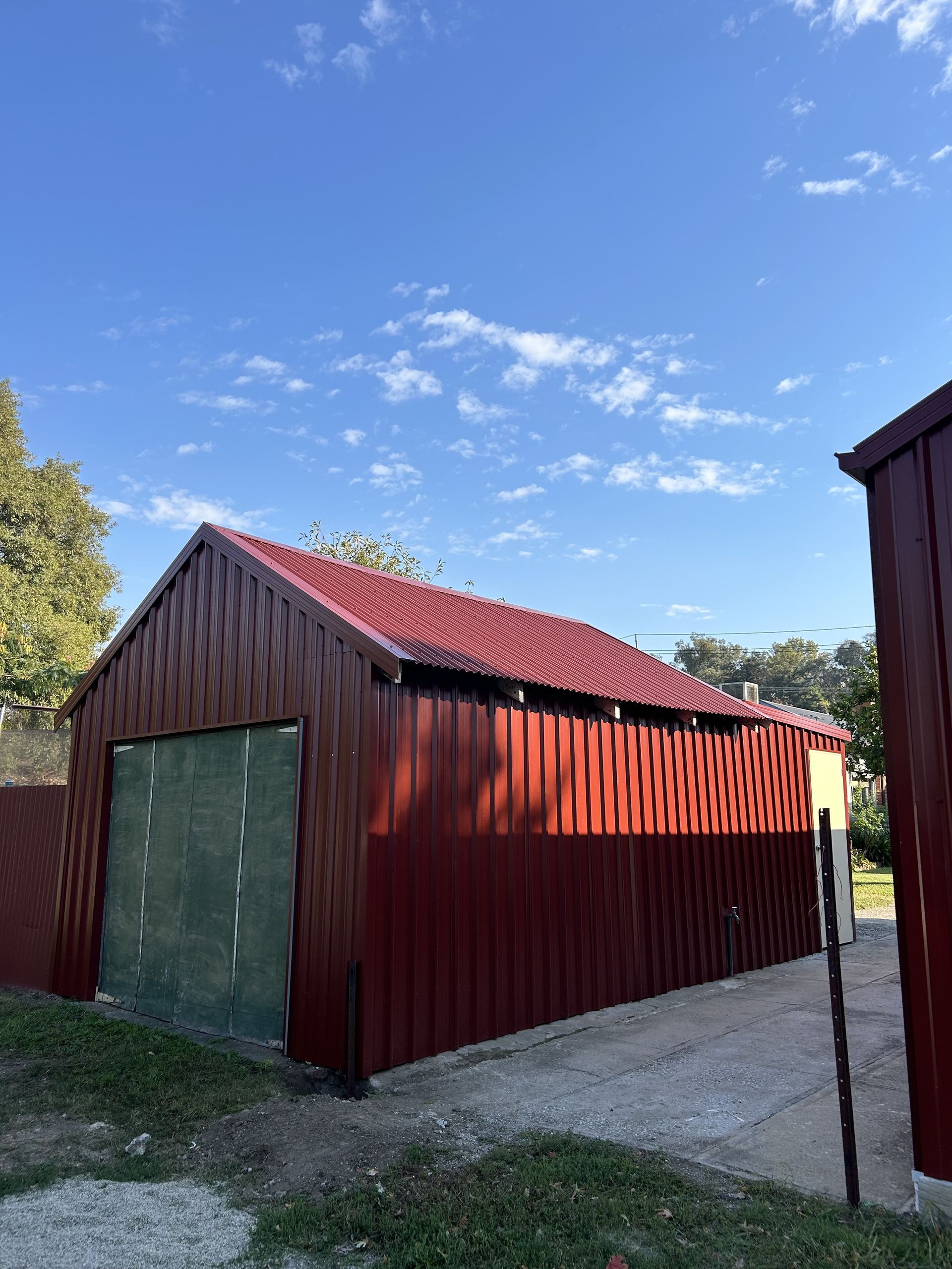 Red Metal Garage With Green Door, Gravel Driveway — The Wright Way Building In North Albury, NSW