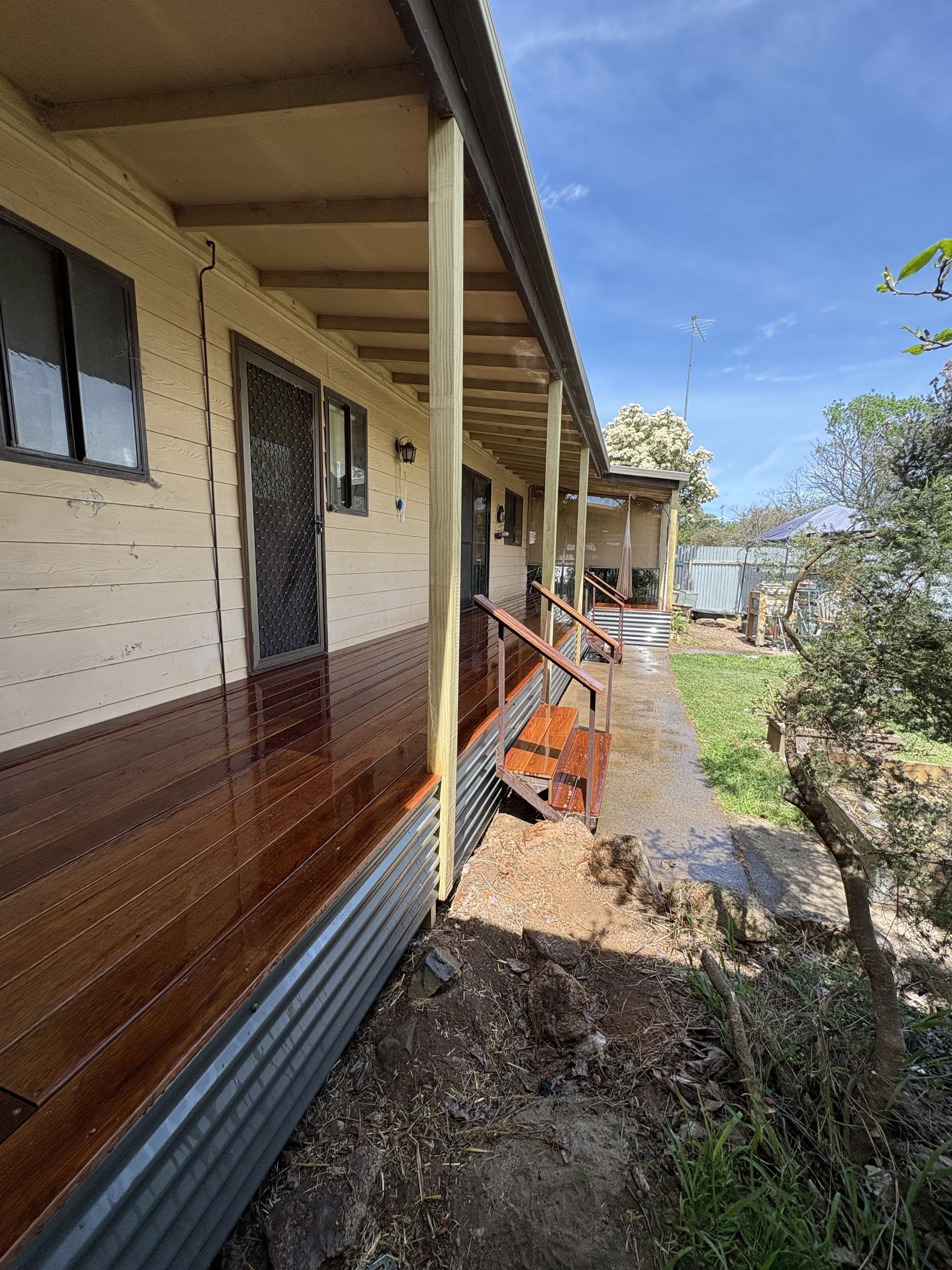 Wooden porch with a brown deck, metal roofing, and cream-coloured house, in an outdoor setting — The Wright Way Building In North Albury, NSW
