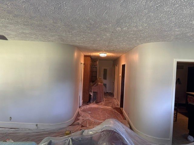 Hallway with walls and floor covered in protective plastic sheeting during renovation
