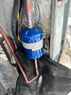 A blue filter is attached to a copper pipe.