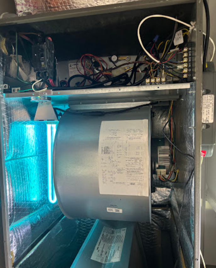 The inside of an air conditioner with a fan and a uv light.