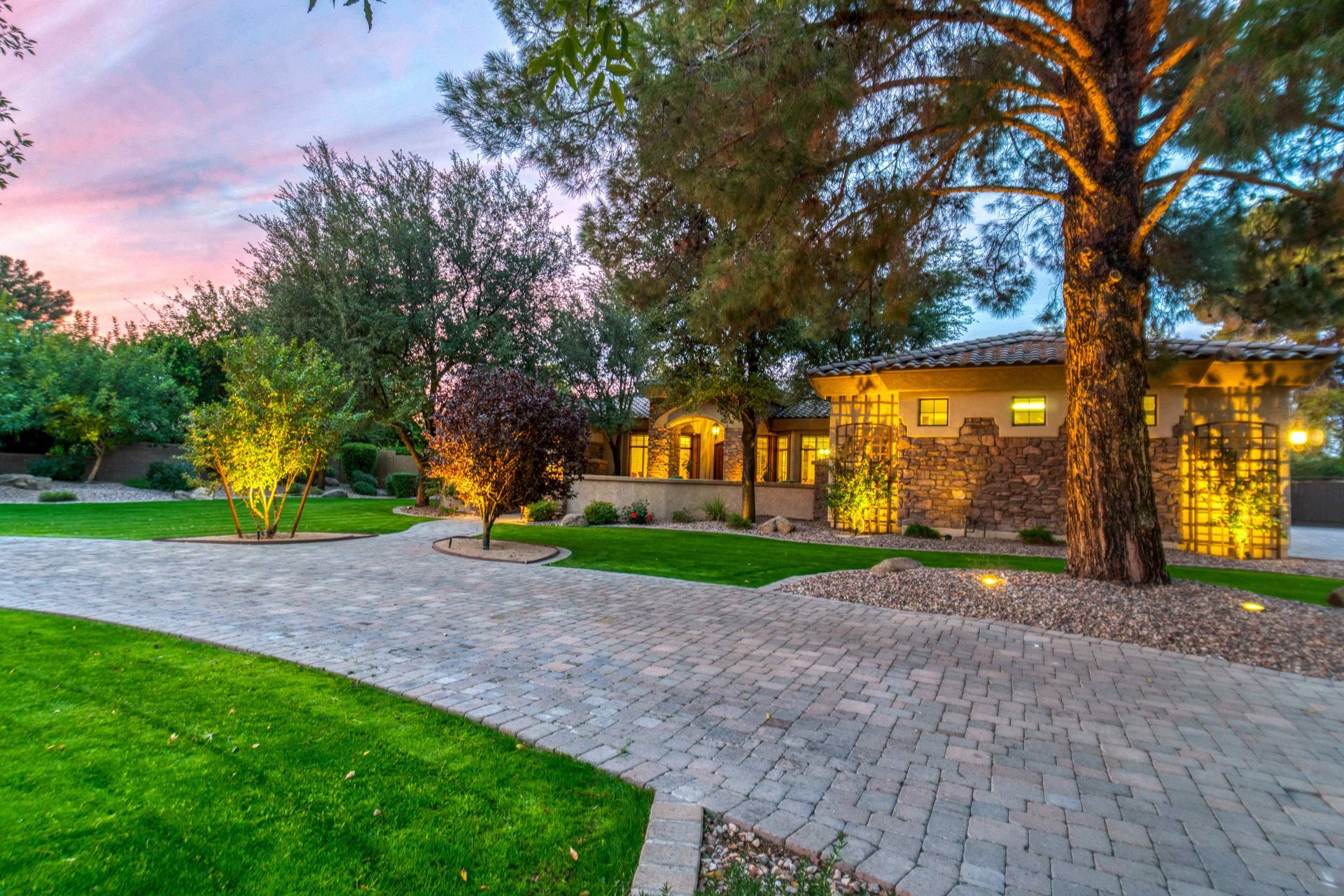 hardscaped paver driveway surrounded by a fully landscaped and irrigated yard
