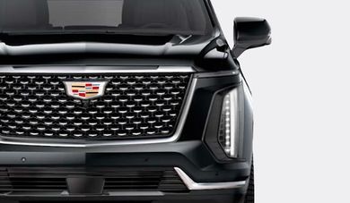 Vista frontal de un SUV Cadillac negro con parrilla y emblema cromados.