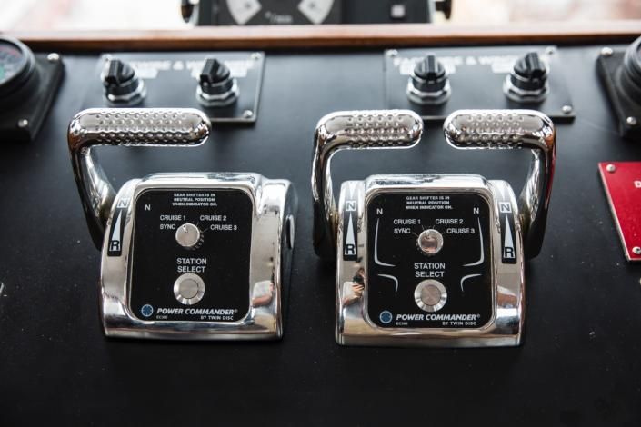 Boat engine controls with two chrome levers, black panel.