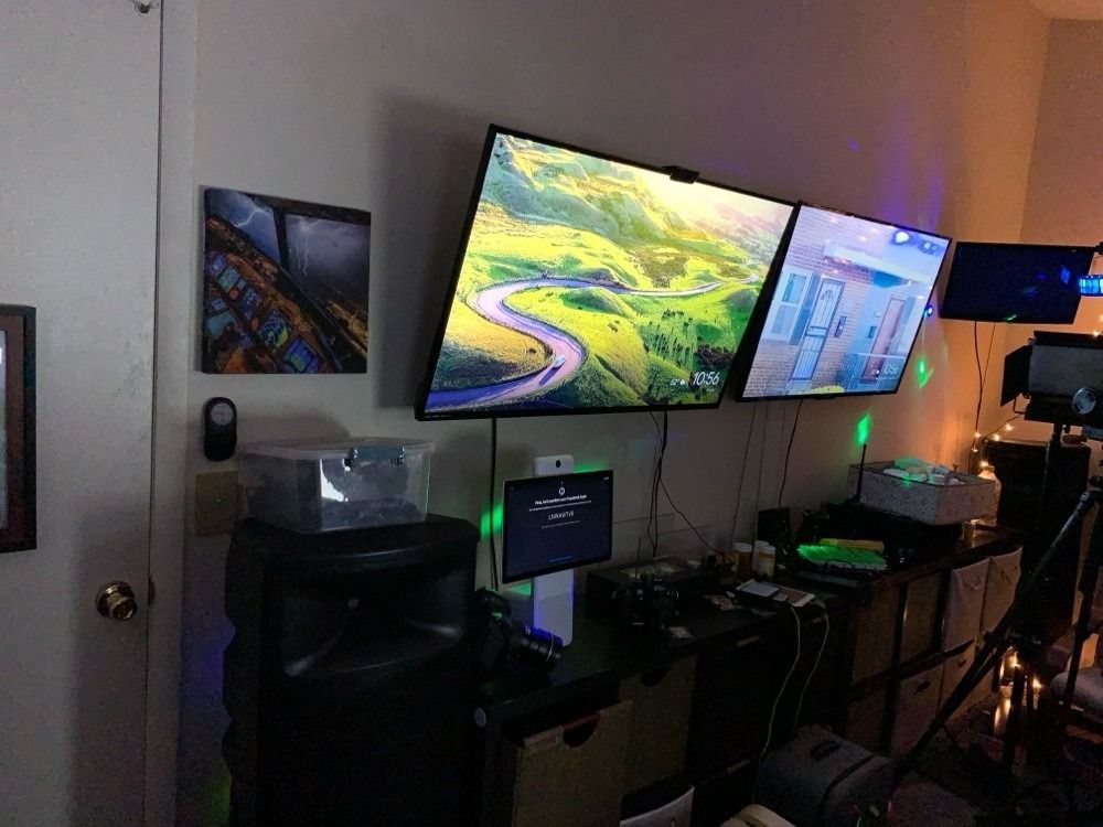 A room with three computer monitors hanging on the wall.