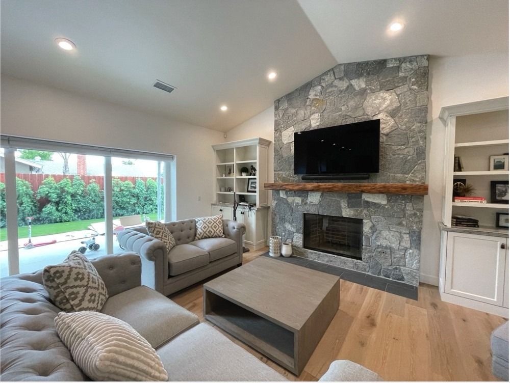 A living room with a fireplace , couch , coffee table and television.