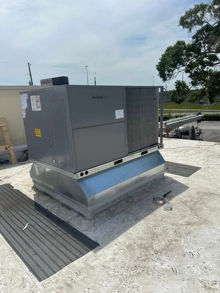 A large gray box is sitting on top of a white roof.